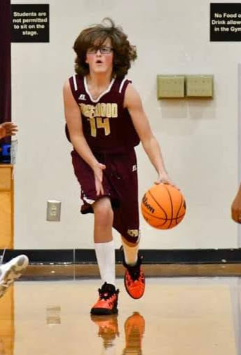 Ben dribbling a basketball during a middle school game